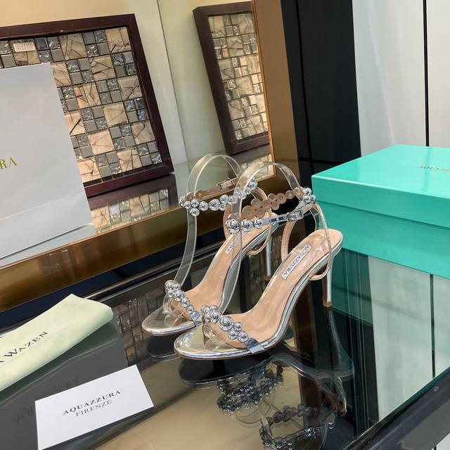 Aquazzura 2024 新款凉鞋 代购品质 鞋子面料采用原版定制漆皮包边。定制装饰扣制作。闪闪发光的电镀装饰扣高跟凉鞋 上脚超级有气质 交叉设计，时尚感满